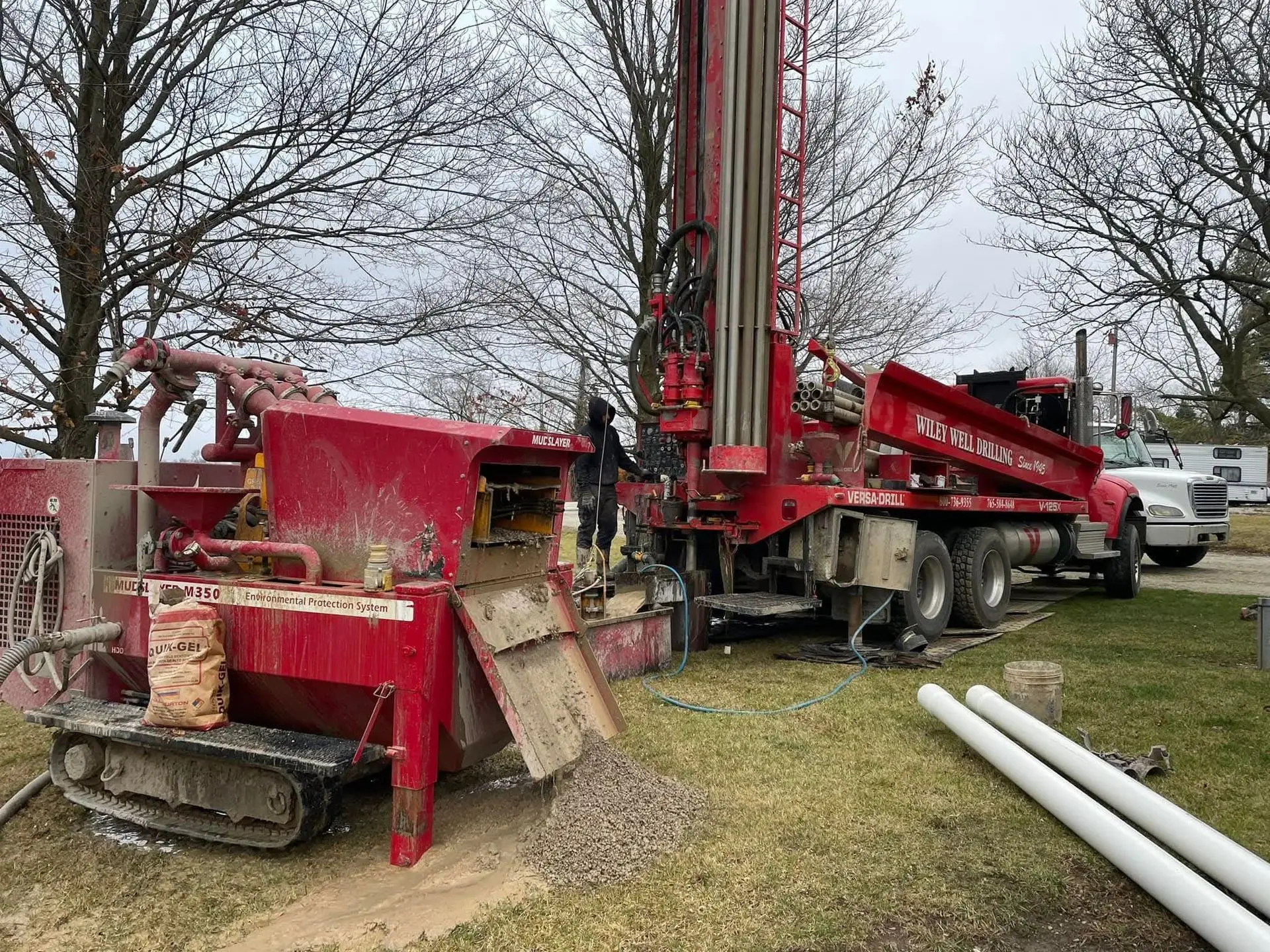 A Wiley Well Drilling rig and mud-recovery system drilling a new water well on a residential property.